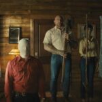 Knock at the Cabin 2023 Movie Scene Dave Bautista as , Leonard, Nikki Amuka-Bird as Sabrina, and Abby Quinn as Adriane holding their weapons as they're preparing to kill Rupert Grint as Redmond
