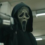 Scream VI 2023 Movie Scene Ghostface Killer wearing his mask and holding a shotgun pointed at the screen